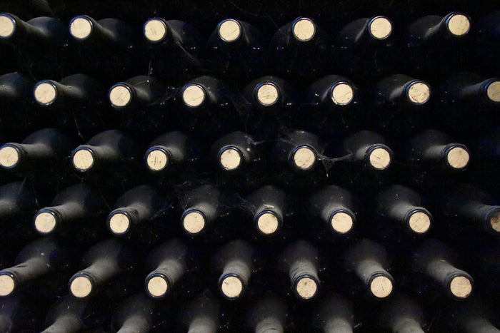 Bouteilles de vin alignées dans une cave, vue rapprochée