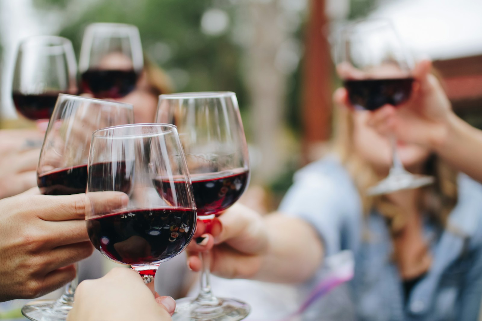 Verre de vin rouge servi à table avec une planche de fromages et charcuteries françaises