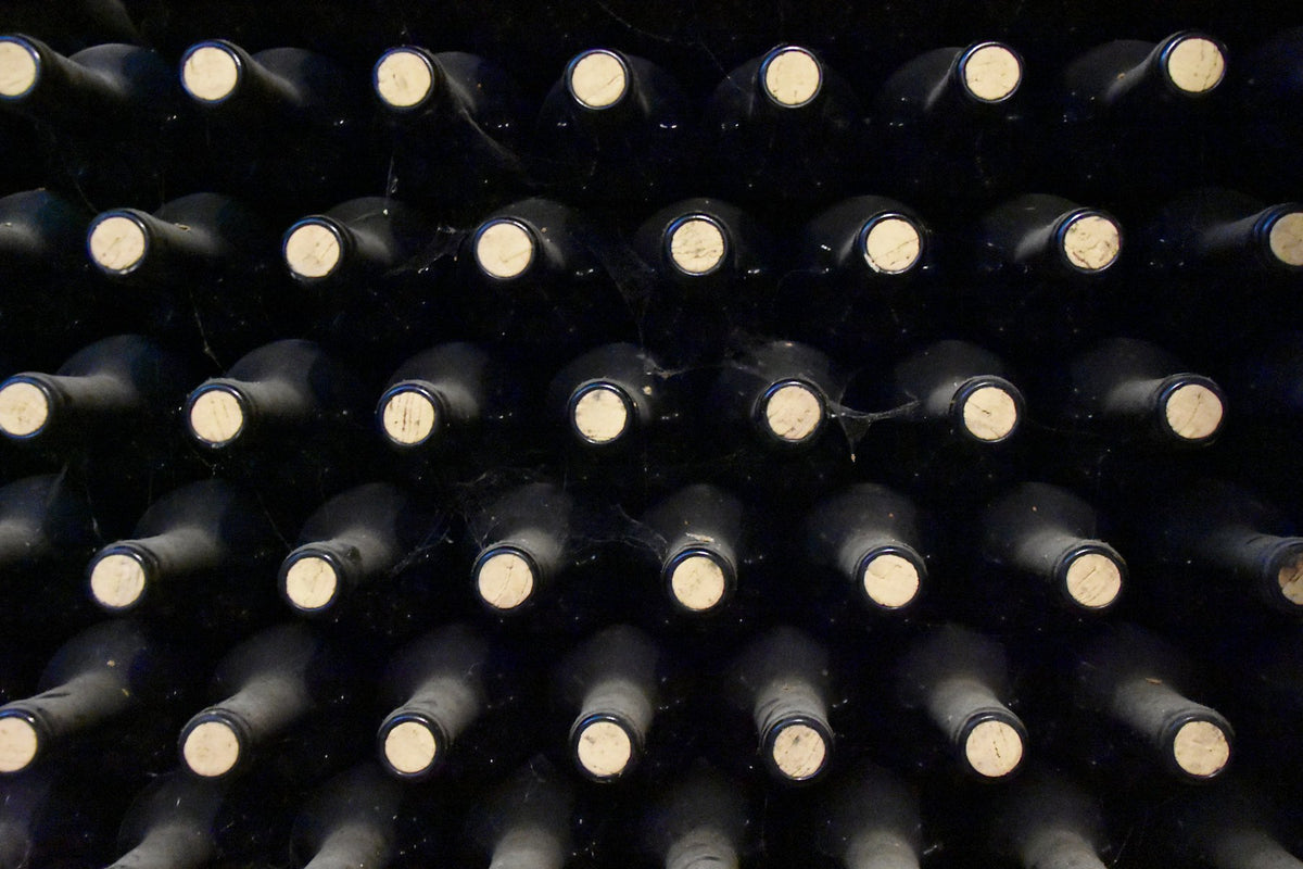 Bouteilles de vin alignées dans une cave, vue rapprochée