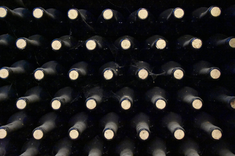 Bouteilles de vin alignées dans une cave, vue rapprochée